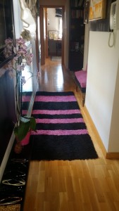 Alfombra hecha de recortes de otras alfombras en negro y rosa